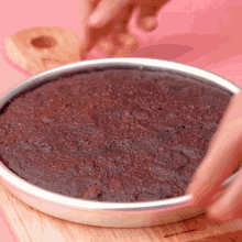 a brownie in a pan on a wooden cutting board