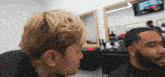 a man with a beard is getting his hair cut