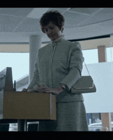 a woman in a white suit is standing in front of a podium