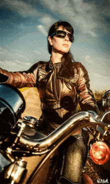 a woman wearing sunglasses rides a motorcycle