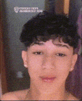 a young man with curly hair is wearing earrings and a necklace ..