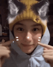 a person wearing a yellow hat with cat ears on their head