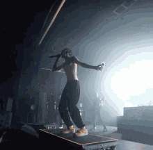 a shirtless man is singing into a microphone on stage