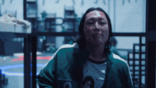 a man with blood on his face is wearing a green jacket