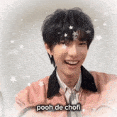 a young man wearing a pink jacket is smiling with the words pooh de chofi written below him