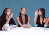 a group of women sit at a table with blue champagne glasses