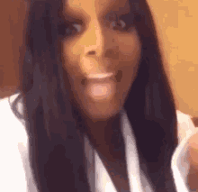a woman with long black hair is wearing a white robe and making a funny face