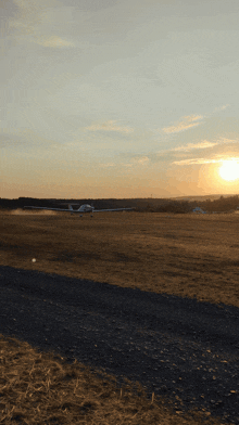 a small plane is taking off at sunset with the sun behind it