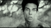 a shirtless man is making a funny face in a black and white photo