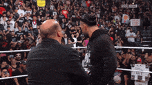 two men in a wrestling ring with a sign that says i 'm a real guy on it