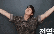 a man in a military uniform has his arms outstretched in front of a black wall