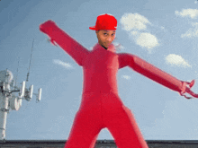 a man in a red jumpsuit with arms outstretched