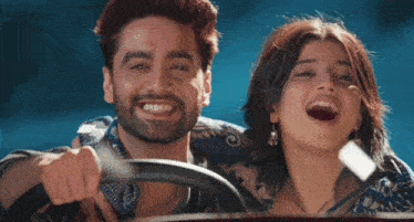 a man and a woman are sitting in a car and smiling