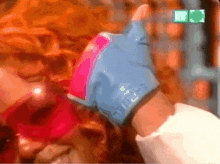 a person wearing a blue and pink glove that says ' tbtv ' on it