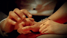 a man is putting a wedding ring on a woman 's finger .