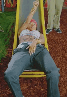 a woman laying on a slide with the word barbie written on her chest