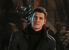 a man in a black jacket is standing in front of a sign that says 5th