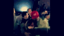 a blurry picture of a group of people standing around a man .