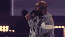 a group of people singing in front of a large screen that says cause all i want is all you are