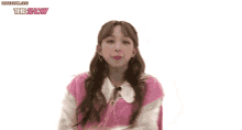 a woman in a pink vest and white shirt is standing in front of a white background with the show written on it