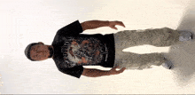 a man wearing a denim t-shirt and khaki pants