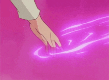 a hand is touching a pink surface with a purple glow