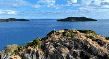 a person standing on top of a rocky cliff overlooking the ocean