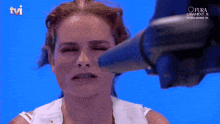 a woman 's face is being blow dried by a tvi logo