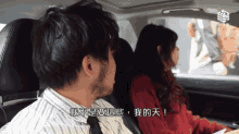 a man and a woman in a car with chinese writing on it