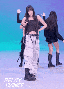 a girl in a black top and white pants is dancing in front of a relay dance sign