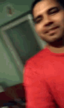 a man in a red shirt is making a face