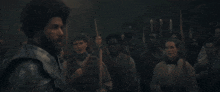 a man in armor is standing in front of a crowd