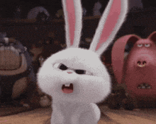 a white bunny rabbit with pink ears is standing on a wooden floor .