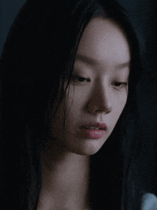 a close up of a woman 's face with long black hair