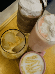 three different types of drinks on a wooden tray