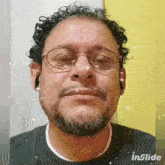 a man with glasses and a beard is making a funny face .