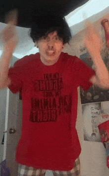 a man wearing a red shirt that says " tommy hilfiger " on it