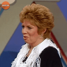 a woman with a scarf around her neck and a buzzr logo on the bottom right