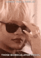 a woman wearing sunglasses and a ring is talking on a phone .