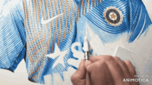 a person is holding a lighter in front of a blue shirt that says " made in animatica "