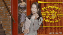 a woman is standing in front of a sign that says gongyoument vintage shop