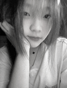 a black and white photo of a girl wearing a shirt that says ' converse ' on the front