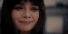 a close up of a woman 's face with a slight smile on her face