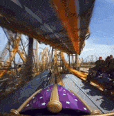 a roller coaster with a purple and gold item on it