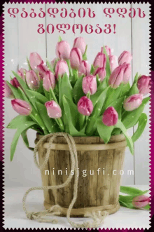 a bouquet of pink flowers in a wooden bucket with the website ninisjgufi.com written below it