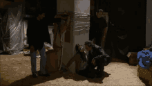 a man is kneeling down next to a woman who is tied up with duct tape