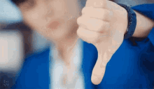 a close up of a person giving a thumbs down sign .