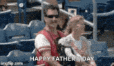 a man and a woman are sitting in a stadium with the words happy father 's day on the bottom .