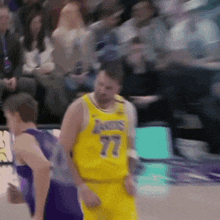 a basketball player wearing a yellow jersey with the number 77