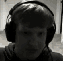 a young man wearing headphones looks at the camera .